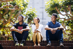 students sitting in the sun near campanile